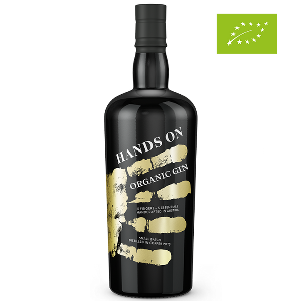 DAVID GÖLLES HANDS ON Organic Gin in schwarzer Flasche mit goldenem Handabdruck und Bio-Logo.