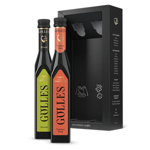Gölles Duo Mediterran: Olivenöl und Tomaten Essig neben offener schwarzer Geschenkbox.