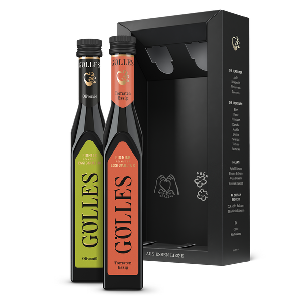 Gölles Duo Mediterran: Olivenöl und Tomaten Essig neben offener schwarzer Geschenkbox.