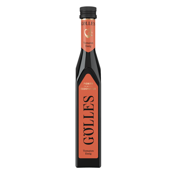 Gölles Tomaten Essig in hoher eckiger Flasche mit orangefarbenem Etikett und schwarzem Verschluss.