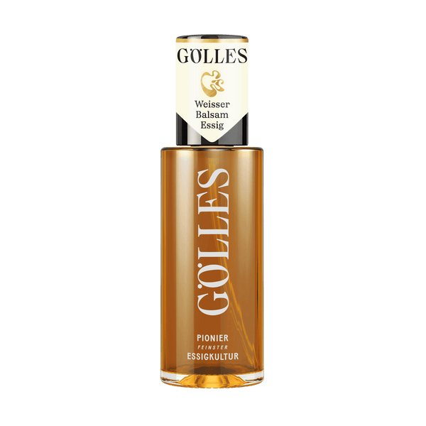 Gölles Weißer Balsamessig, goldgelb, in hoher Glasflasche mit weiß-schwarz-goldenem Etikett.